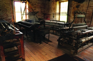 Watkins Woolen Mill State Historic Site. These extremely rare textile machines–two ring-framed ply twisters and a plain loom of 1860 vintage–demonstrate Watkins Woolen Mill’s fame as America’s finest preserved nineteenth-century textile factory. The mills has been designated a National Historic Landmark. Photo credit:Ron Ginther 